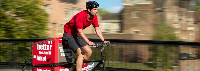 A guy riding a delivery bike